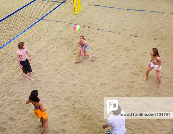 Aerial view of friends playing indoor beach volleyball
