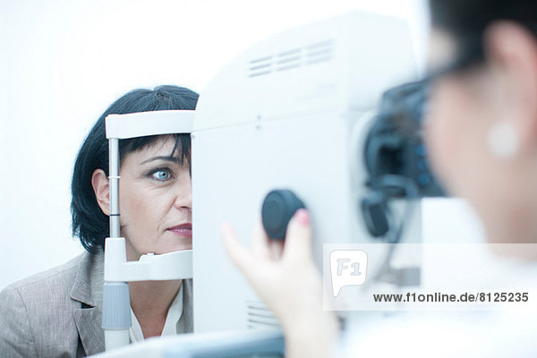 Close up of optician monitoring patient in eye clinic