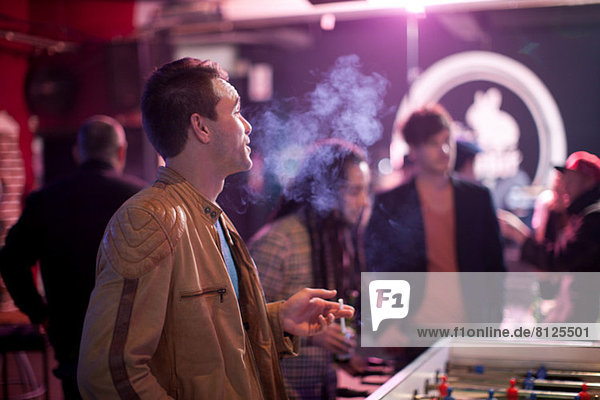 Man smoking cigarette in bar