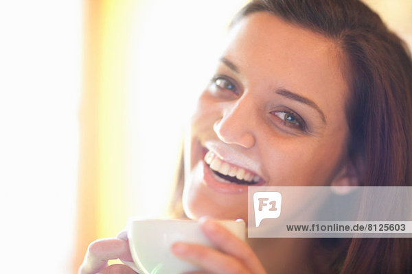 Nahaufnahme einer jungen Frau im Café mit Schaumstoffschnurrbart
