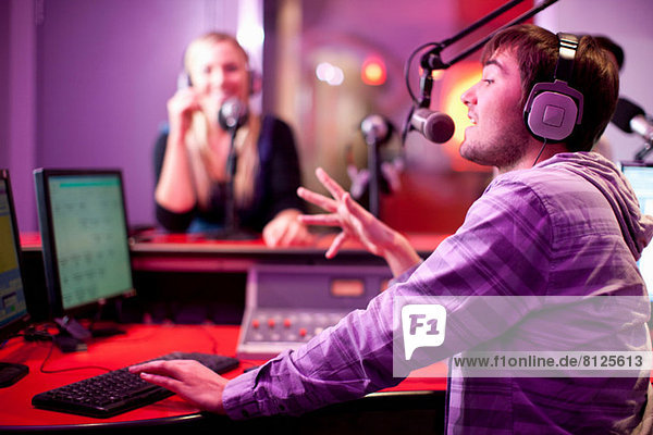 Young man and woman broadcasting in recording studio
