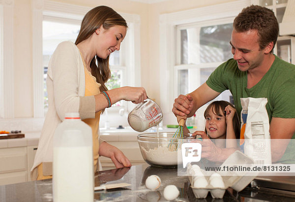 Young girl baking with older brother and sister