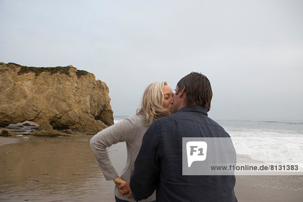 Mature couple kissing on beach