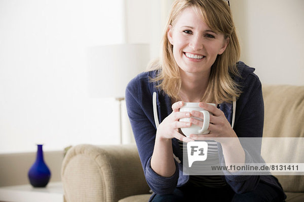Junge Frau hält Kaffee