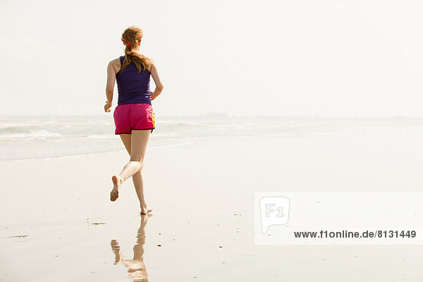 Reife Frau beim Joggen am Strand