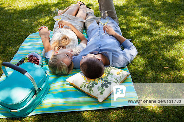 Junges Paar auf Picknickdecke liegend