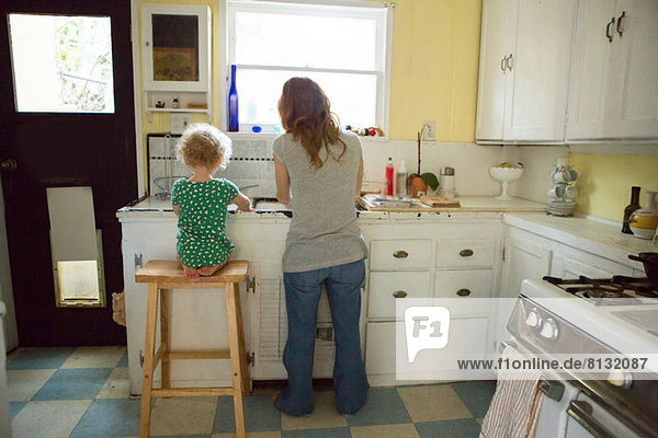 Mother and child at kitchen sink