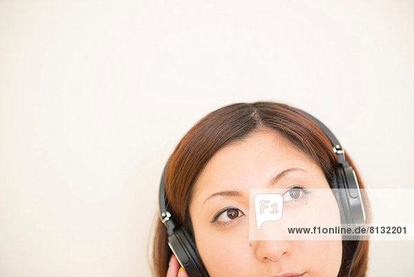 Woman wearing earphones looking upward
