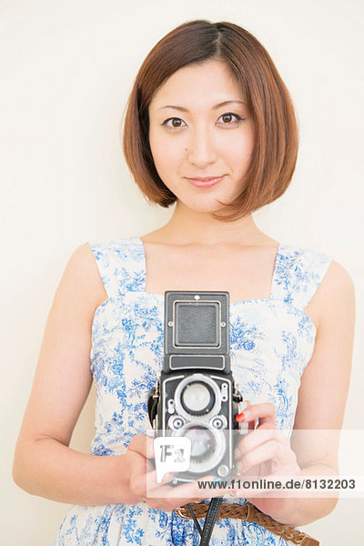 Smiling woman holding a 1960's classic camera