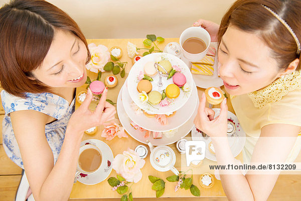 Zwei glückliche Frauen  die in süßen Kuchen schwelgen.