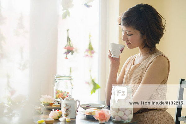 Frau schaut auf die Teetasse herab