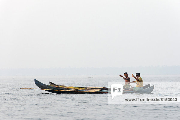 Zwei Fischer in ihren Booten  winkend
