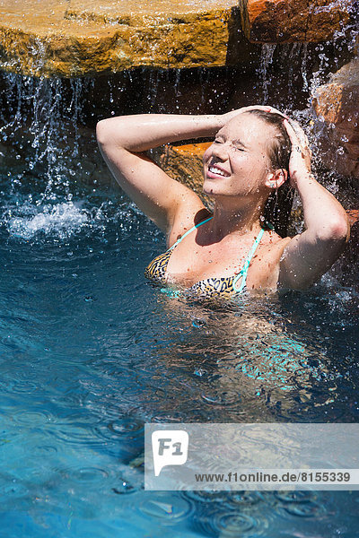 Young woman relaxing in swimming pool  smiling