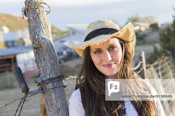 Caucasian woman smiling by barbed wire fence