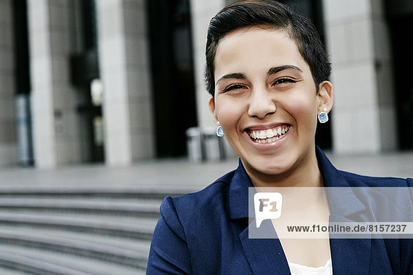 Hispanic businesswoman laughing outdoors