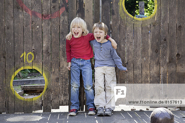 Deutschland  Nordrhein-Westfalen  Köln  Jungen spielen auf dem Spielplatz  lächeln