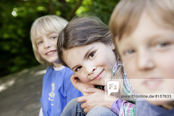 Deutschland  Nordrhein-Westfalen  Köln  Portrait von Mädchen und Jungen auf dem Spielplatz  lächelnd