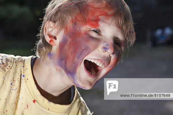 Deutschland  Nordrhein-Westfalen  Köln  Junge spielt mit Farben auf dem Spielplatz  lächelnd