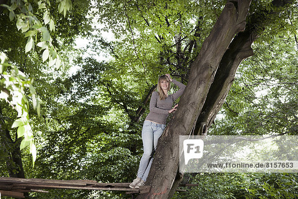 Germany  North Rhine Westphalia  Cologne  Young woman standing on wood