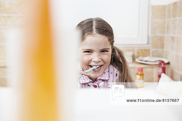 Deutschland  Nordrhein-Westfalen    Portrait eines Mädchens beim Zähneputzen im Bad