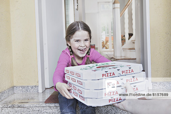 Deutschland  Nordrhein-Westfalen  Köln  Mädchen nimmt Pizzakartons vom Zusteller  lächelnd