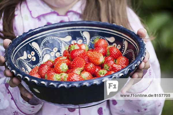 Deutschland  Nordrhein-Westfalen  Köln  Mädchen hält Schale mit Erdbeeren  Nahaufnahme