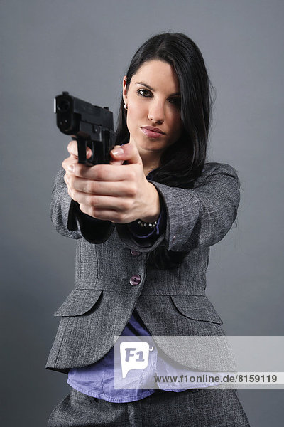 Young woman wearing holding gun  portrait  close up
