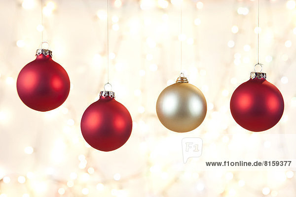 Weihnachtskugeln hängend vor glänzendem Hintergrund  Nahaufnahme