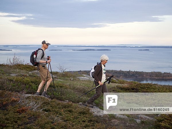 A retired couple enjoys a hike on on the Maine coast.