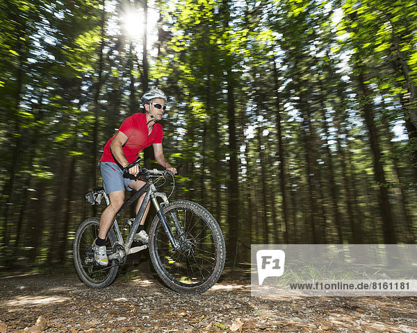 Cyclist on a mountainbike riding through a forest