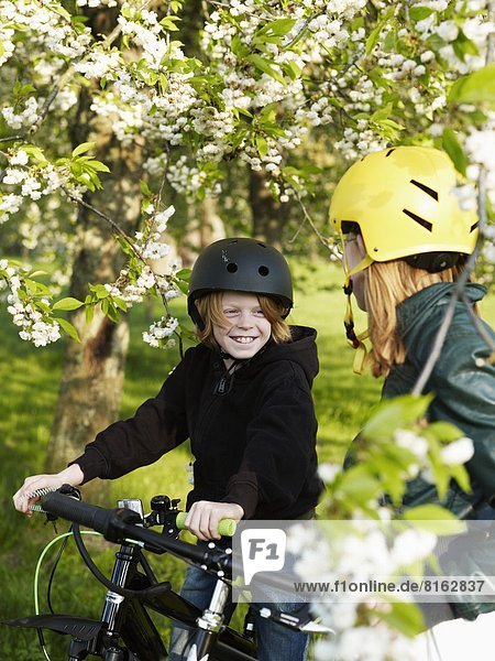 Boy and girl cycling in park