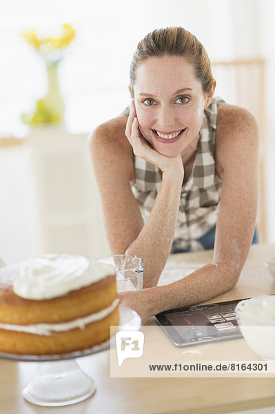 Portrait of woman using tablet pc in kitchen