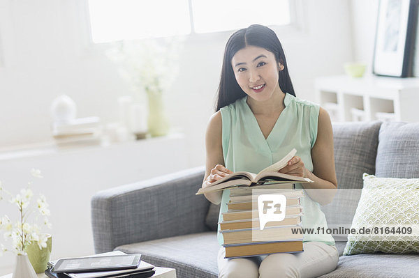 Woman with stack of books at home