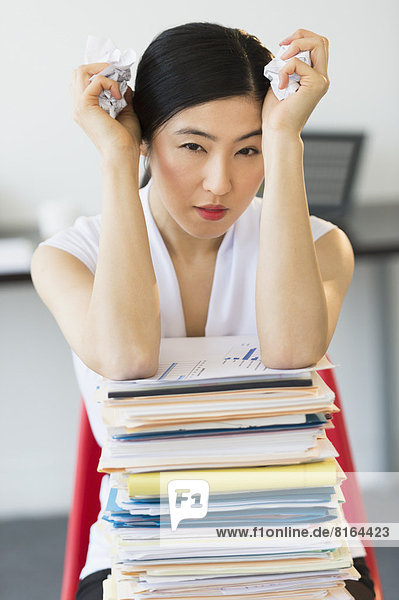 Portrait of businesswoman with stack of files