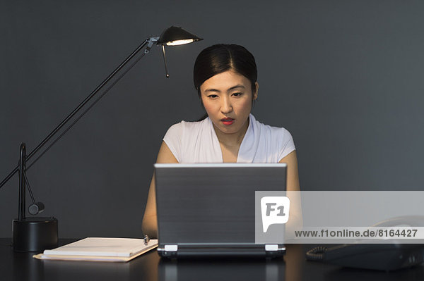 Businesswoman working on laptop at night