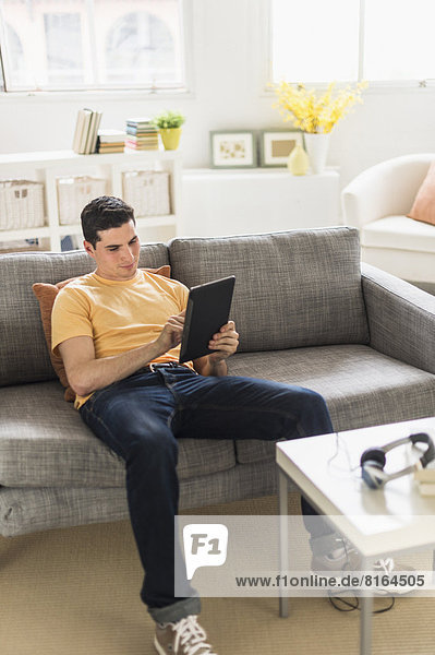 sitzend  benutzen  Mann  Couch  Tablet PC