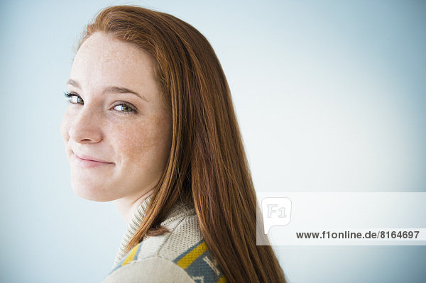 Portrait of smiling teenage girl (14-15)  studio shot