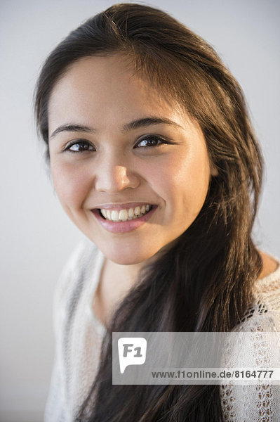 Studio shot of beautiful young woman smiling