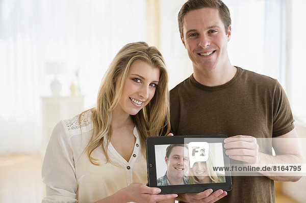 Portrait of young couple holding their picture