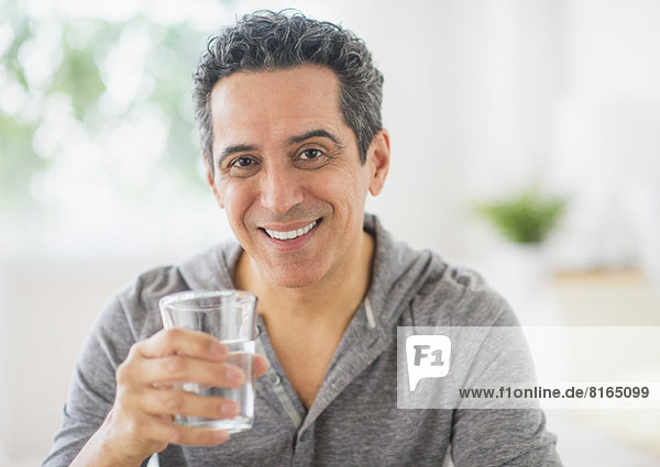Portrait of mature man holding glass of water