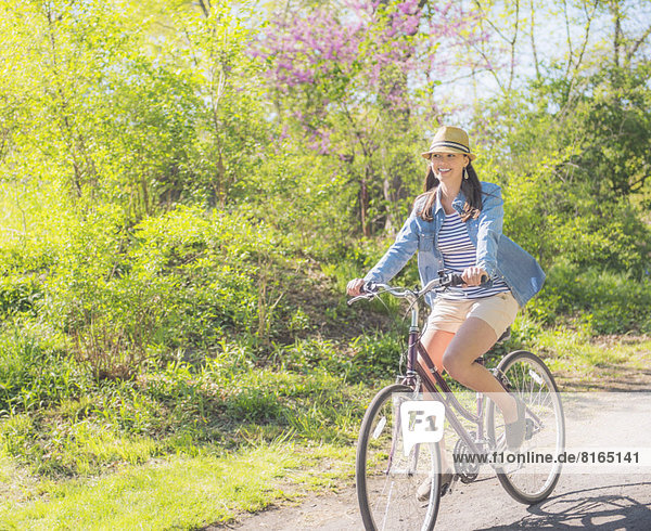 Mid adult woman riding bicycle