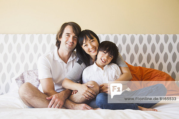 Portrait of family sitting on bed