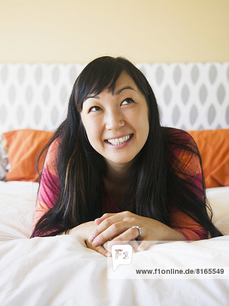 Portrait of mid adult woman laying on bed