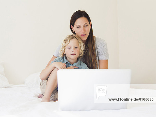 Mother with son (6-7) using laptop