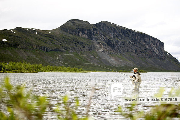 Man fishing in mountain lake