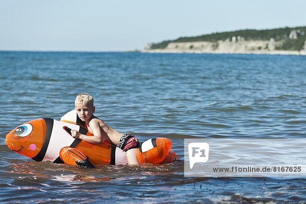 Boy swimming in sea on inflatable toy