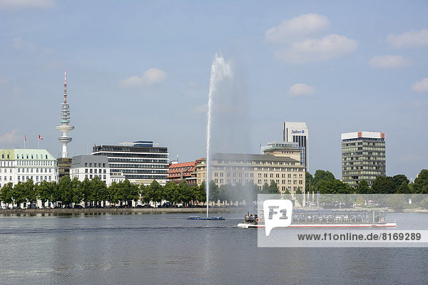 View over the Inner Alster Lake with Alster Fountain and an Alster excursion boat towards the street of Neuer Jungfernstieg  Hotel Vier Jahreszeiten or Four Seasons Hotel and the television tower at the rear