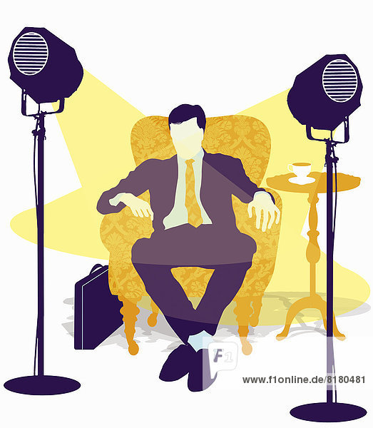 Spotlights on businessman sitting in armchair