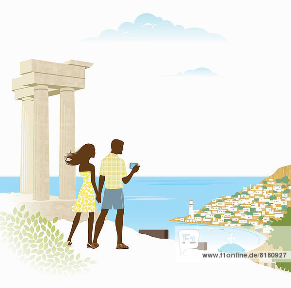 Couple taking photograph of scenic view of bay beside ancient ruin