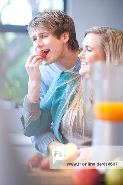 Young couple eating fruit and preparing juice drink